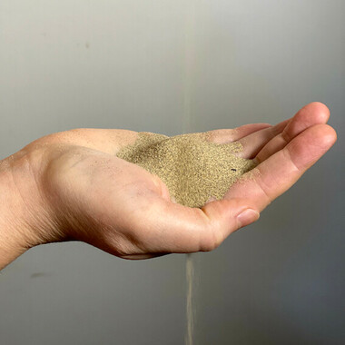 Close-up of a hand with sand trickling into it.