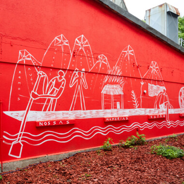Ein Foto der Arbeit TIPIK AND KUNANI: our memory is here: Eine rote Wand mit weißen Zeichnungen.